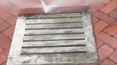 PowerJet high-pressure nozzle effortlessly blasting away years of dirt and debris from a weathered wooden deck surface